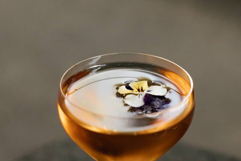 A cocktail garnished with flowers at Baltra Bar