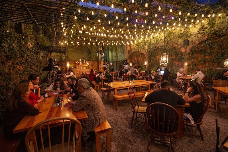 Huset courtyard with wooden tables beneath hanging lights