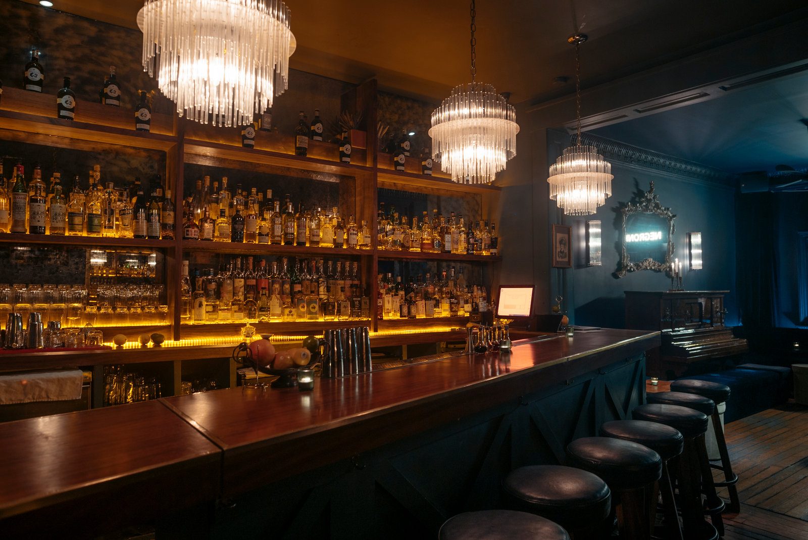 The backlit bar and chandeliers at Maison Artemisia